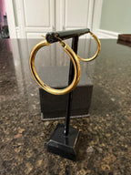 14k yellow gold round hoop earrings angled view on display stand