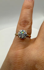 Yellow gold ring with round halo center stone in prong setting, close on finger