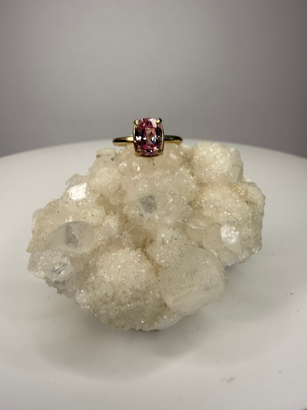 14k yellow gold ring with cushion-cut pink sapphire in four-prong setting