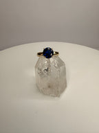 14k yellow gold ring with round dark blue sapphire on clear crystal base