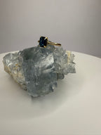 14k yellow gold emerald-cut sapphire ring, dark blue stone in four-prong mount