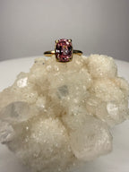 14k yellow gold ring close-up with cushion-cut pink sapphire, four prongs