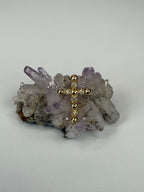 14k yellow gold diamond cross pendant on gray crystal cluster