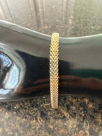 Yellow gold woven mesh bracelet with textured link pattern and slim cuff
