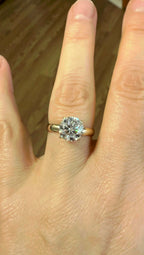 14k yellow gold moissanite ring with large round center stone, close-up on hand