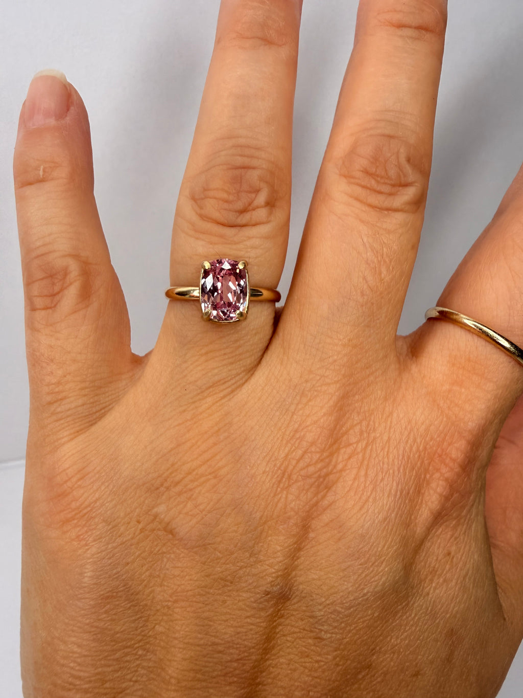 14k yellow gold ring with cushion-cut peach-pink sapphire, four-prong setting