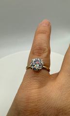 Yellow gold ring with round center stone and halo prong setting on finger