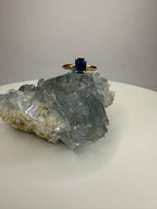 14k yellow gold ring with emerald-cut dark blue sapphire in four-prong setting