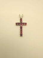 10k yellow gold ruby cross pendant with prong-set ruby gemstones, angled for detail