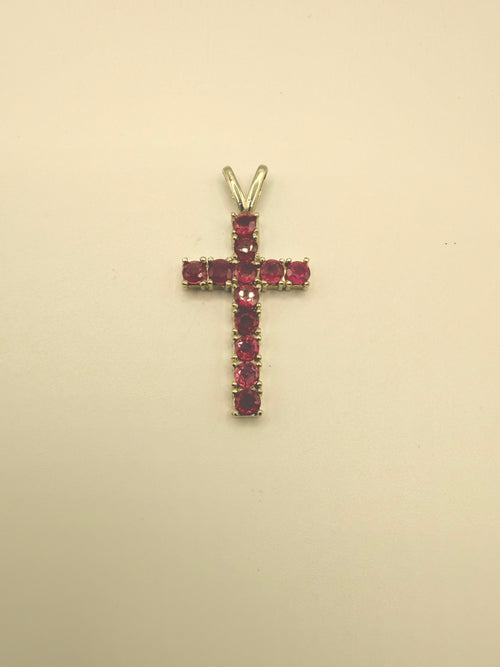 10k yellow gold ruby cross pendant with prong-set ruby gemstones, angled for detail