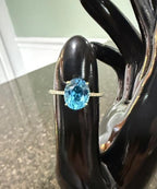 10k yellow gold ring with oval blue topaz gemstone, slim prong-set band