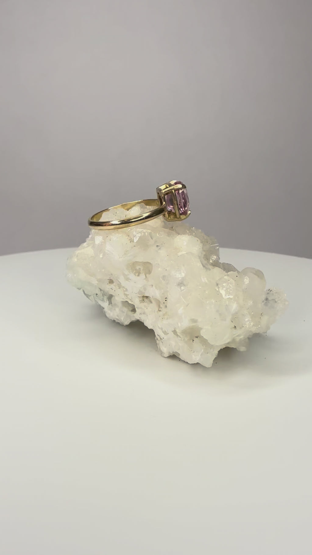 14k yellow gold ring close-up with cushion-cut pink sapphire, four prongs