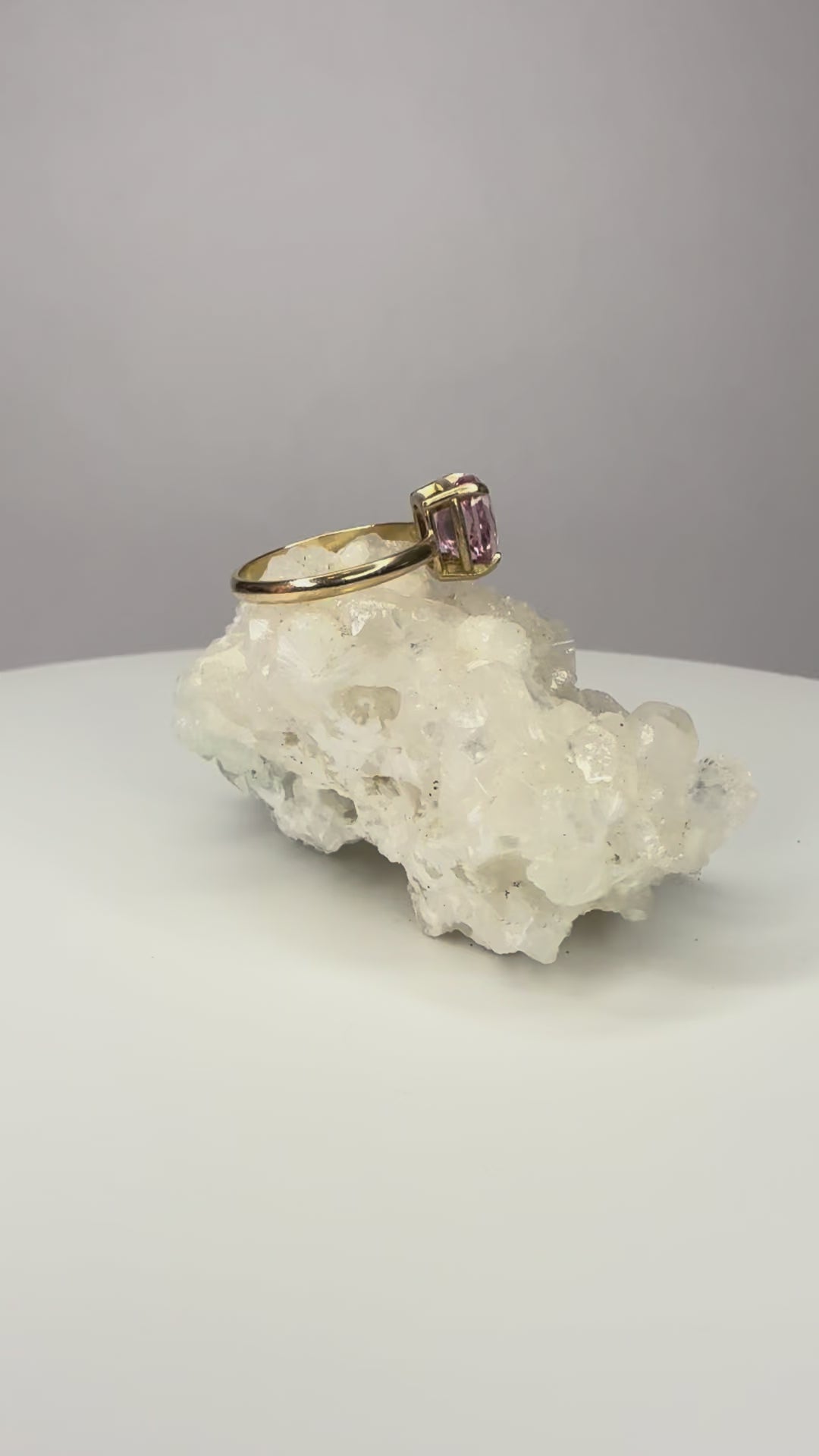 14k yellow gold ring close-up with cushion-cut pink sapphire, four prongs