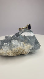 14k yellow gold sapphire ring with emerald-cut dark blue stone, four prongs visible
