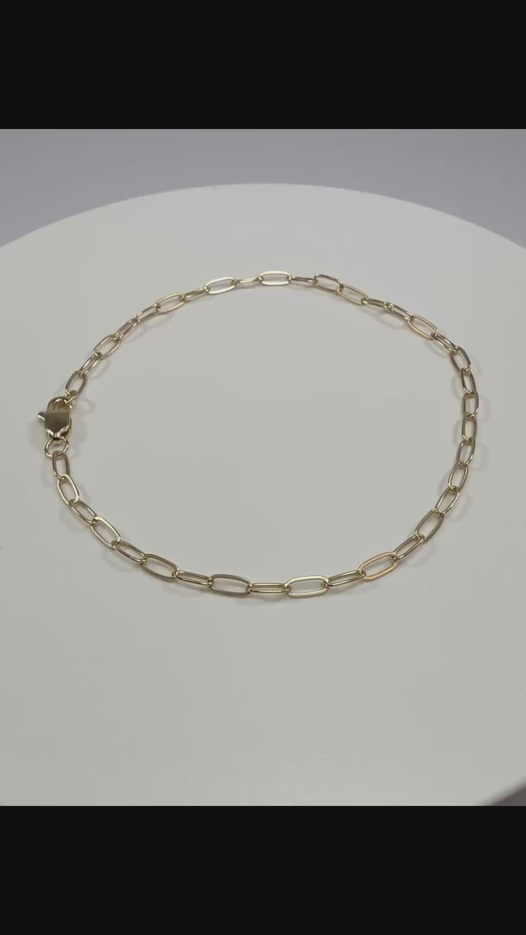 Close up detail of 10k yellow gold 2.1mm paperclip links showing high polish finish and lobster clasp