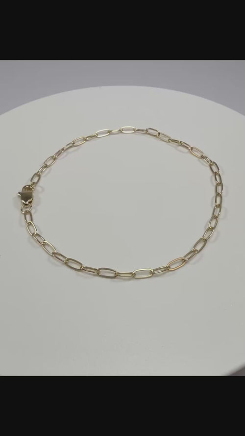 Close up detail of 10k yellow gold 2.1mm paperclip links showing high polish finish and lobster clasp